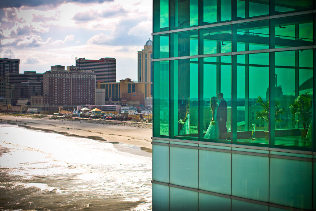 Couple in corner of Atlantic Room with beach background 1024x683 - Couples & Bridal Parties